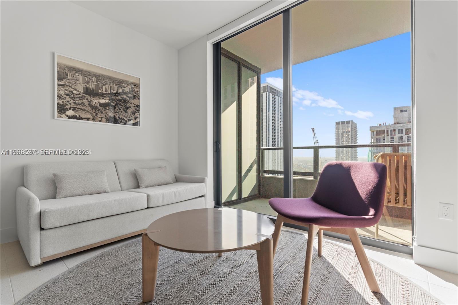 159 Northeast 6th Street, Unit 2403 Miami, FL 33132 - Photo 13 of 16 a living room with furniture and a window