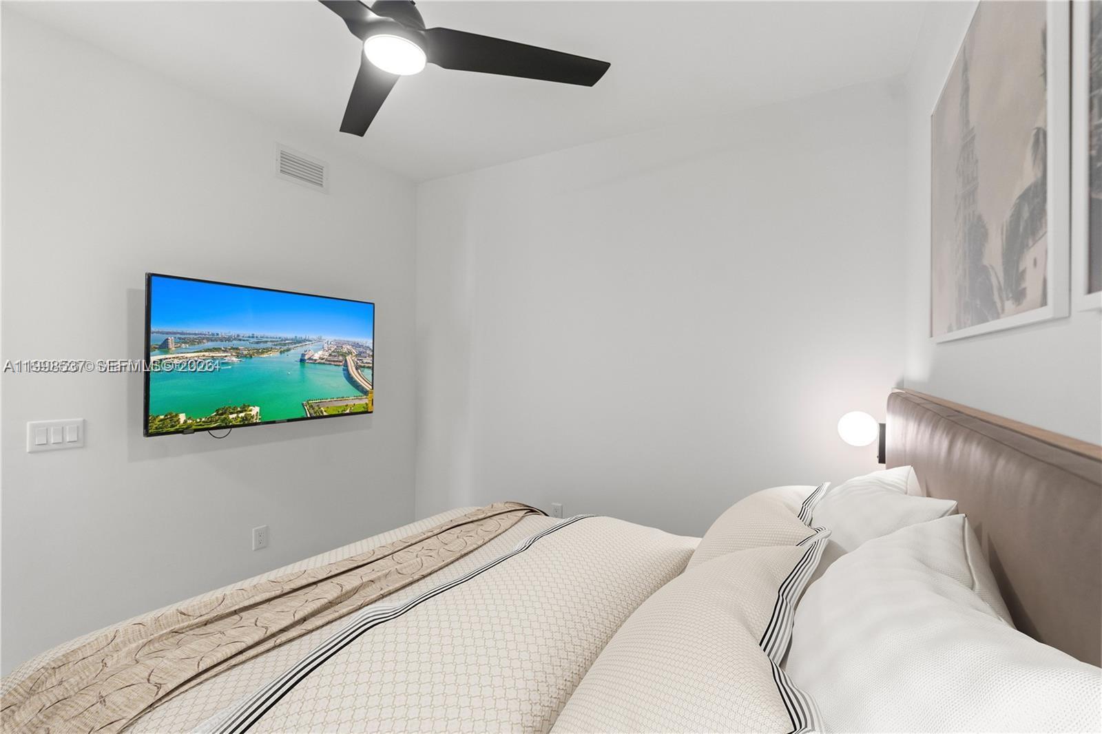 159 Northeast 6th Street, Unit 2403 Miami, FL 33132 - Photo 5 of 16 a bedroom with a bed and a flat screen tv