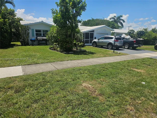 a view of a house with a big yard and potted plants