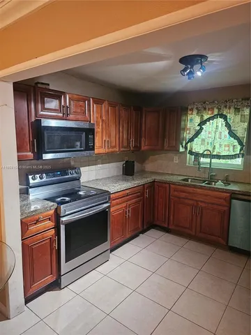 a kitchen with stainless steel appliances granite countertop a stove sink and cabinets