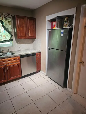 a kitchen with stainless steel appliances granite countertop a refrigerator and a sink