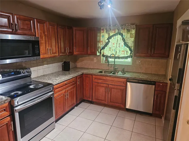 a kitchen with stainless steel appliances granite countertop a stove microwave and sink
