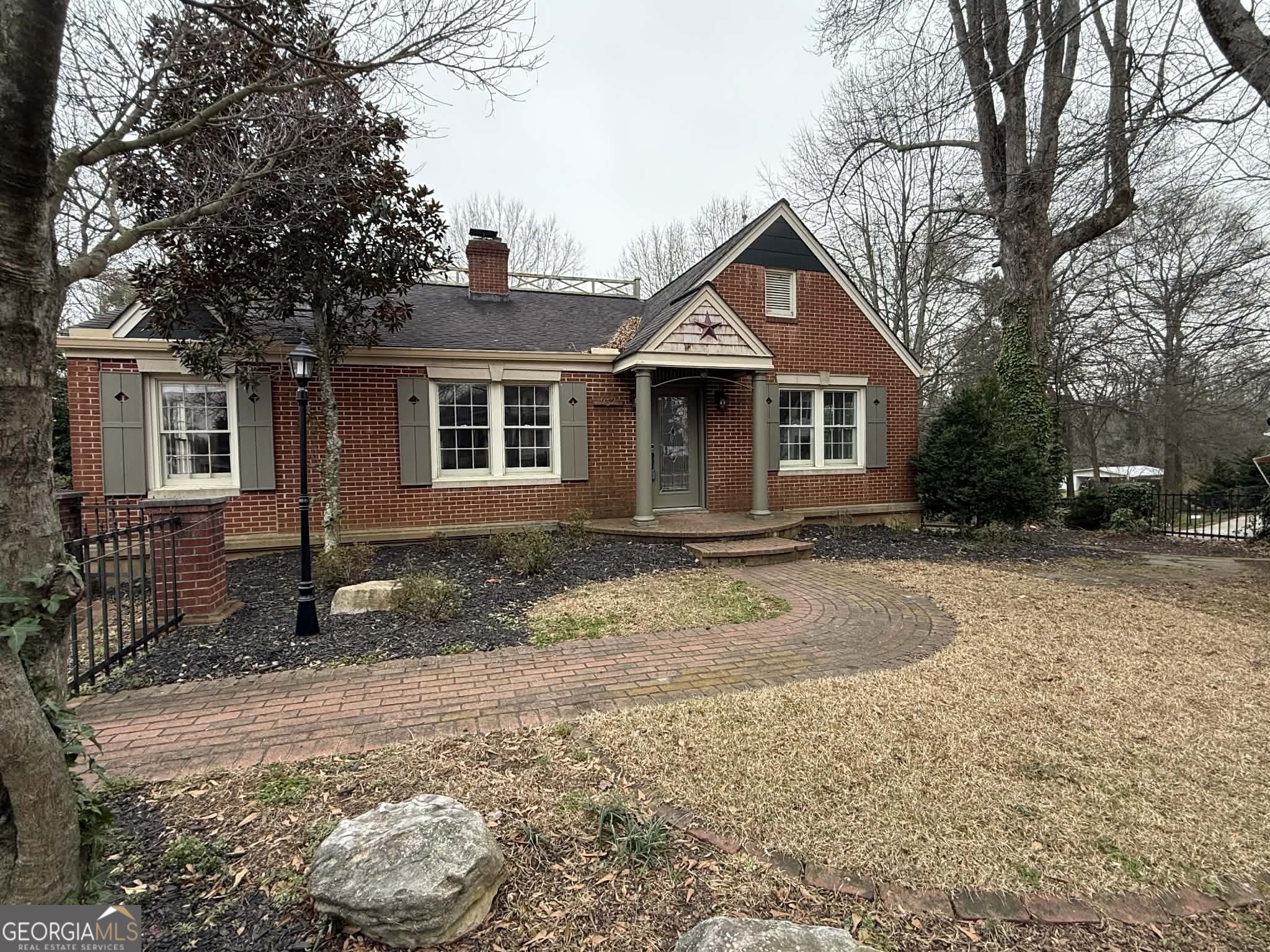 a front view of house with yard and trees around