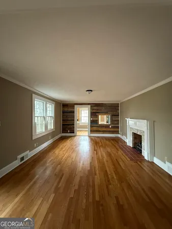 a view of empty room with fireplace and wooden floor