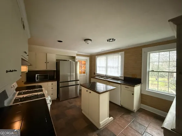 a kitchen with stainless steel appliances a sink stove and refrigerator