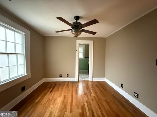 a view of room with window ceiling fan and hardwood floor