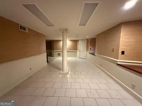 a view of a refrigerator in kitchen and an empty room