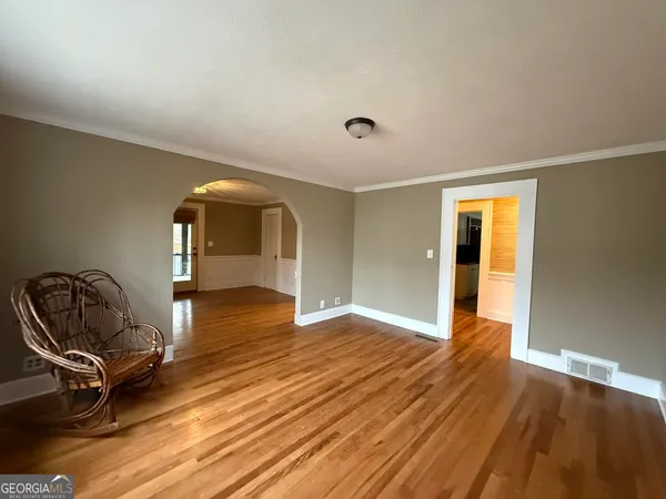 a view of a room with wooden floor lounge chair and windows