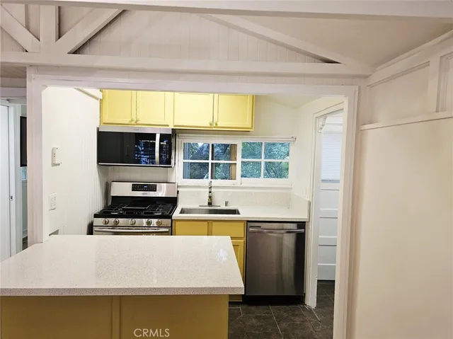 a kitchen with stainless steel appliances a stove a refrigerator and a window