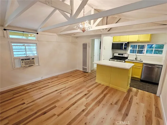 a view of a kitchen with wooden floor and a sink