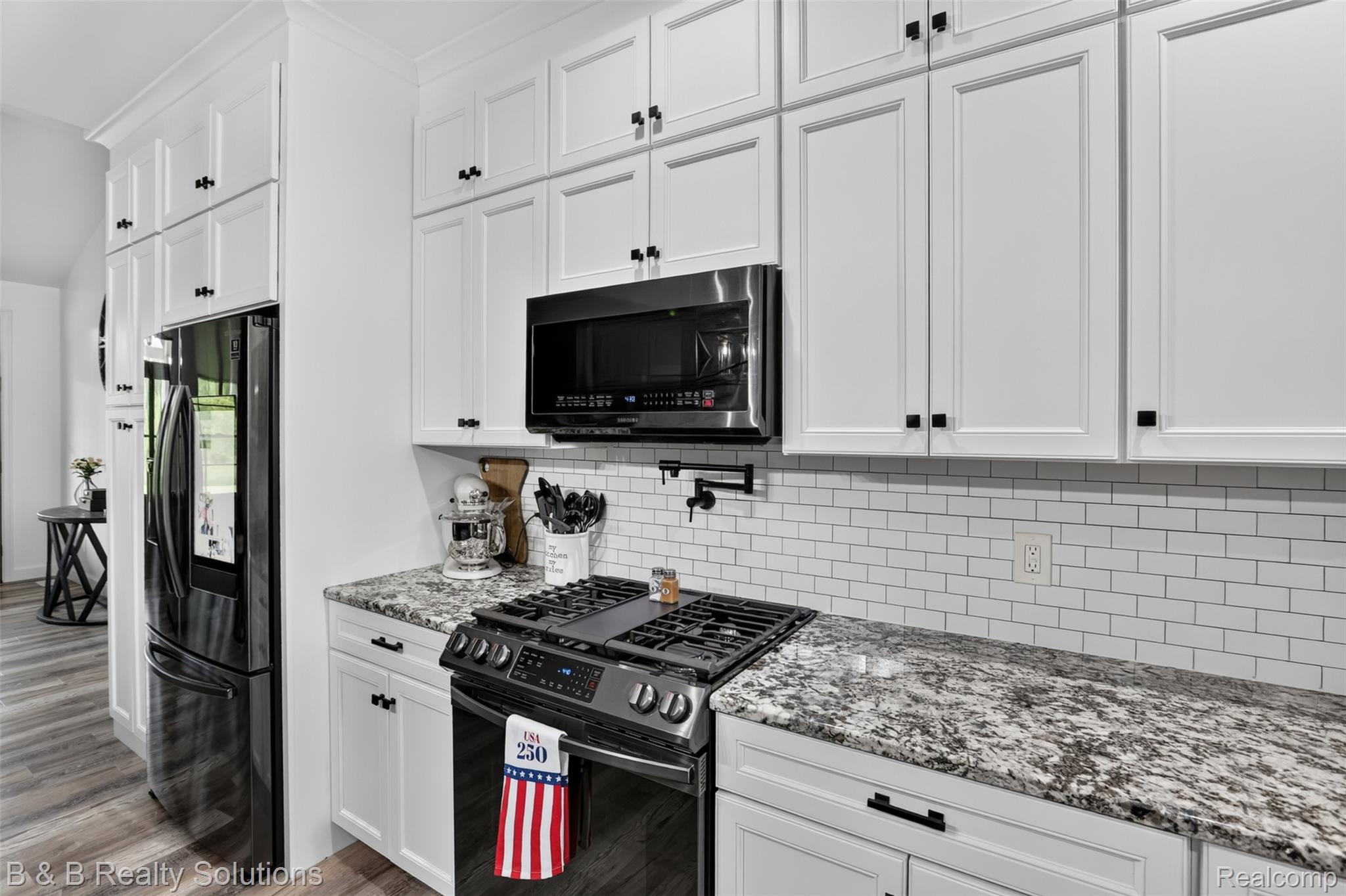 6204 Fish Lake Road North Branch, MI 48461 - Photo 15 of 79 Kitchen featuring white shaker-style cabinetry, dark hardware, light granite countertops, a white subway tile backsplash, and wood-finish flooring