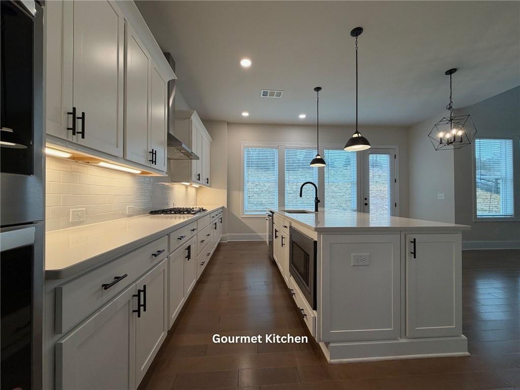 3770 Andover Street Cumming, GA 30028 - Photo 11 of 52 a large kitchen with stainless steel appliances kitchen island granite countertop a stove a sink and a refrigerator
