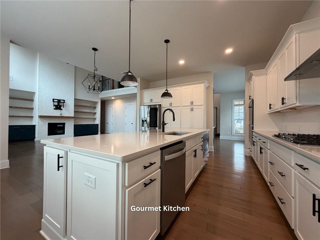 3770 Andover Street Cumming, GA 30028 - Photo 12 of 52 a kitchen with kitchen island a stove a sink a center island and wooden floor