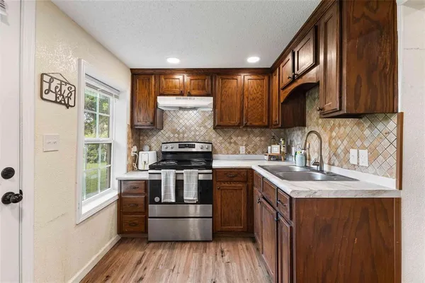 a kitchen with stainless steel appliances granite countertop a stove a sink and a refrigerator