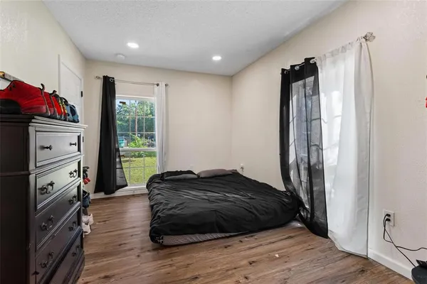 a bedroom with a bed closet and wooden floor