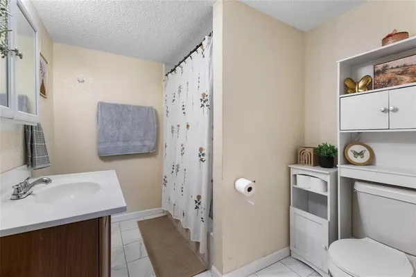 a bathroom with a granite countertop toilet sink and mirror