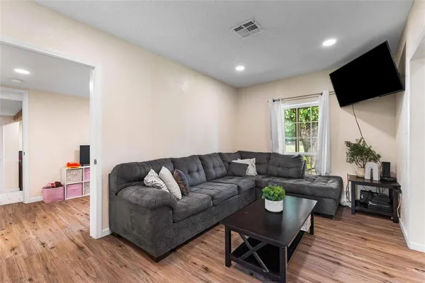 a living room with furniture flat screen tv and wooden floor