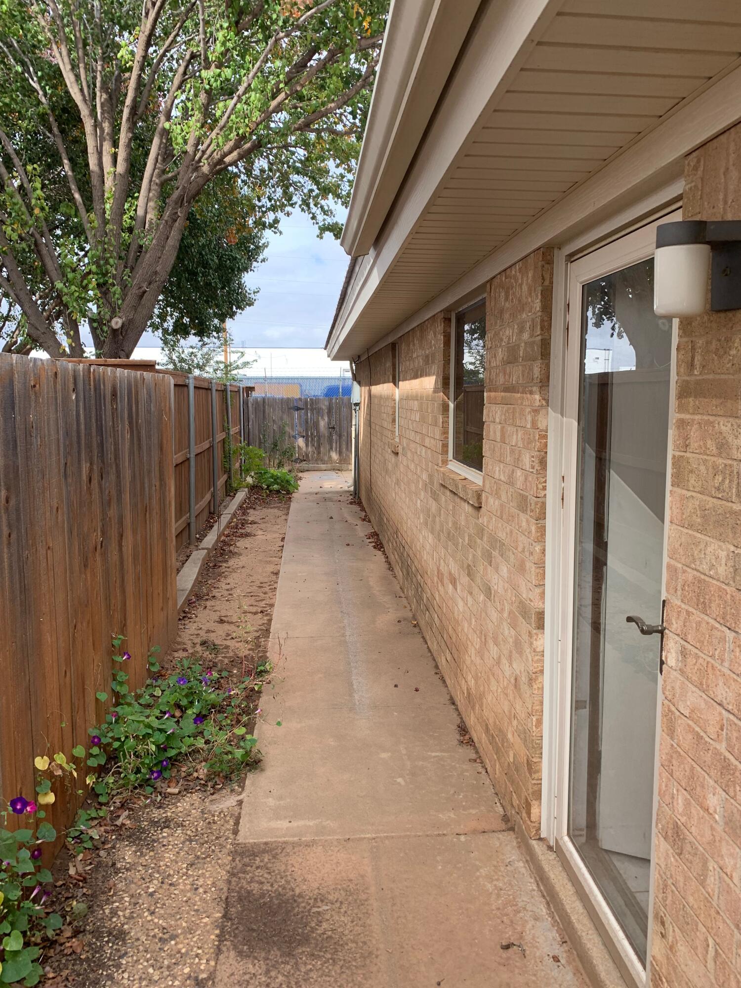 3216 74th Street, Unit B Lubbock, TX 79423 - Photo 11 of 11 a pathway of a house with backyard and trees