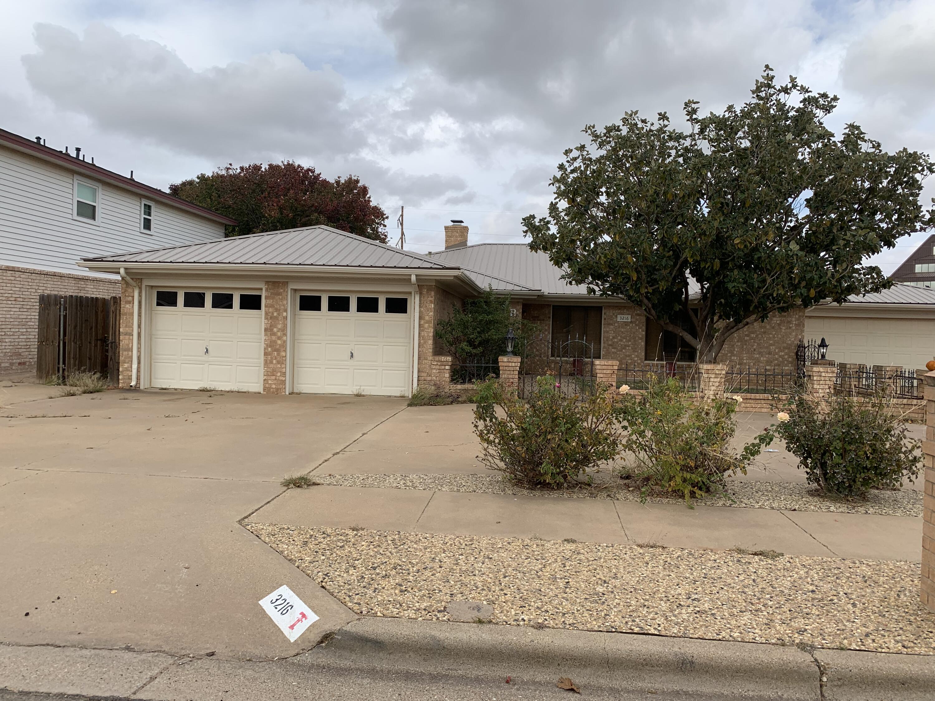 3216 74th Street, Unit B Lubbock, TX 79423 - Photo 2 of 11 a front view of a house with garden