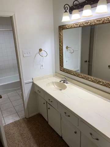 a bathroom with a granite countertop sink and a mirror