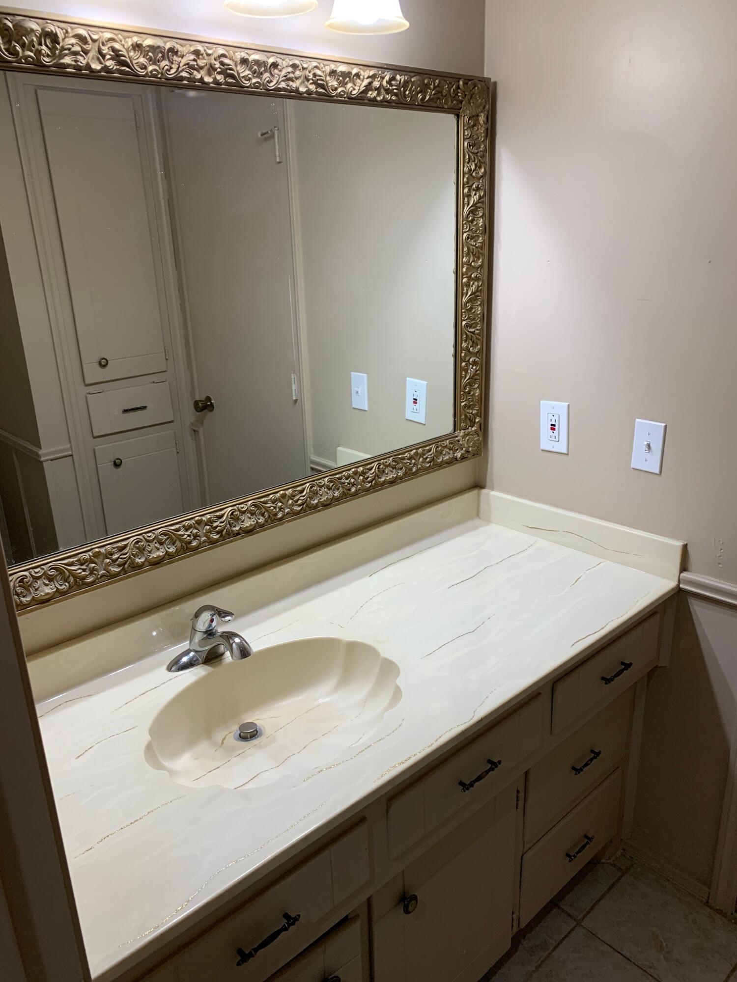 3216 74th Street, Unit B Lubbock, TX 79423 - Photo 8 of 11 a bathroom with a sink and a mirror