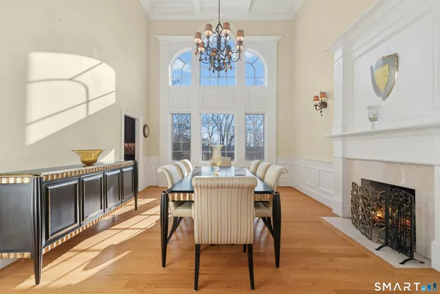 a dining room with furniture a chandelier and wooden floor