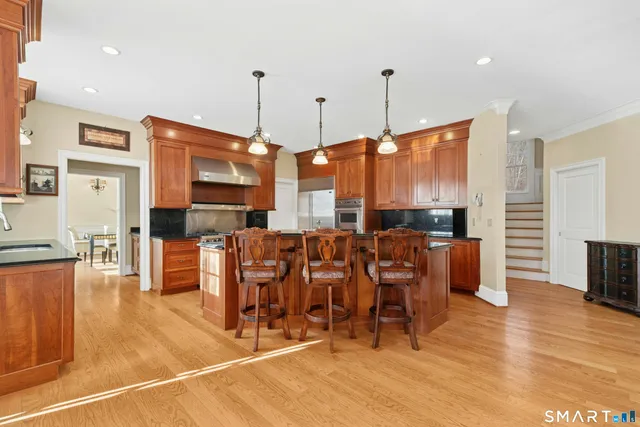 a large kitchen with a large counter top furniture appliances and wooden floor