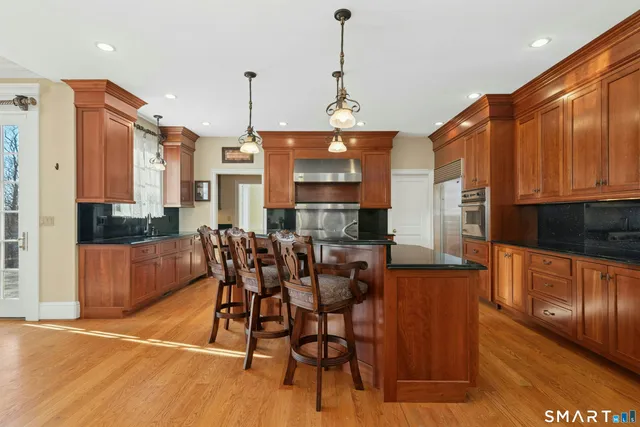 a dining table chairs wooden floor and a kitchen view