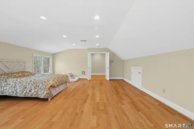 a spacious bedroom with a bed and a dresser