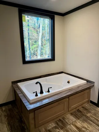 a white bath tub sitting in a bathroom next to a window