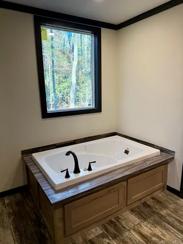 a white bath tub sitting in a bathroom next to a window