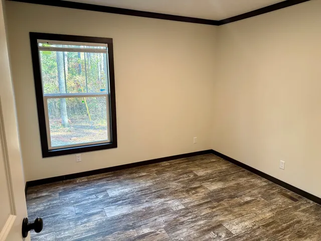 a view of a room with wooden floor and a window