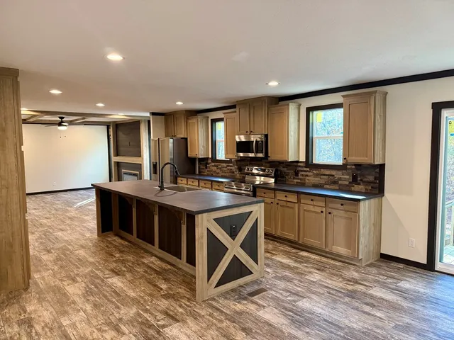 a kitchen with stainless steel appliances granite countertop a stove a sink and a microwave