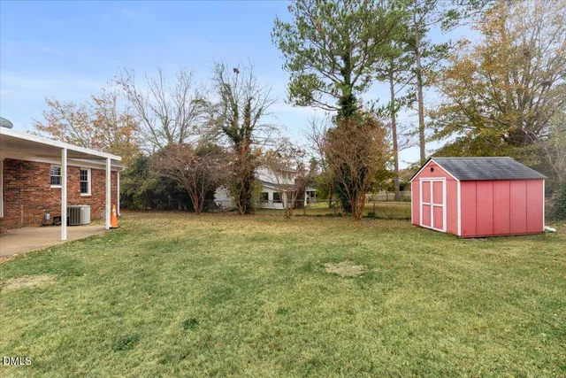 a view of a house with backyard and trees