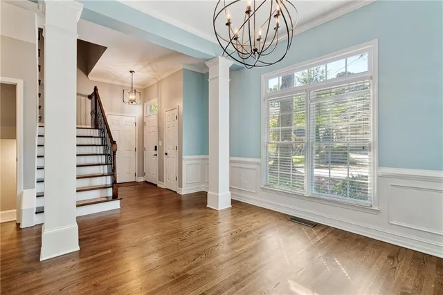 a view of empty room with wooden floor and window