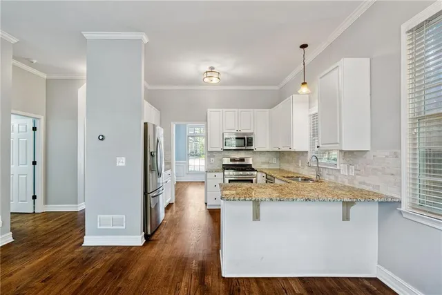 a view of a kitchen with a sink a refrigerator and a stove top oven