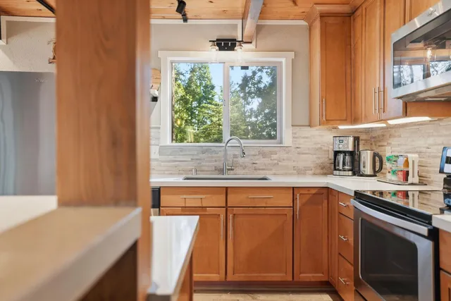a open kitchen with stainless steel appliances granite countertop a sink window and cabinets