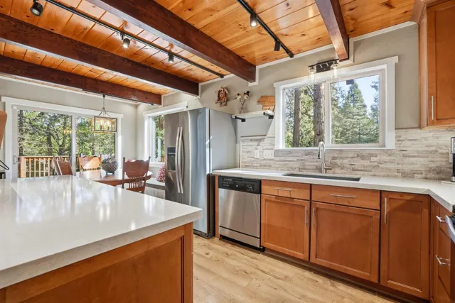 a kitchen with stainless steel appliances granite countertop a refrigerator a stove a sink and a dishwasher with wooden floor