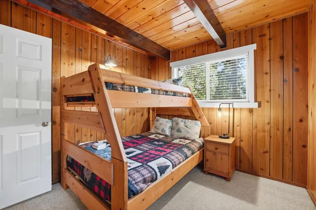 a bedroom with a bed a mirror and a large window