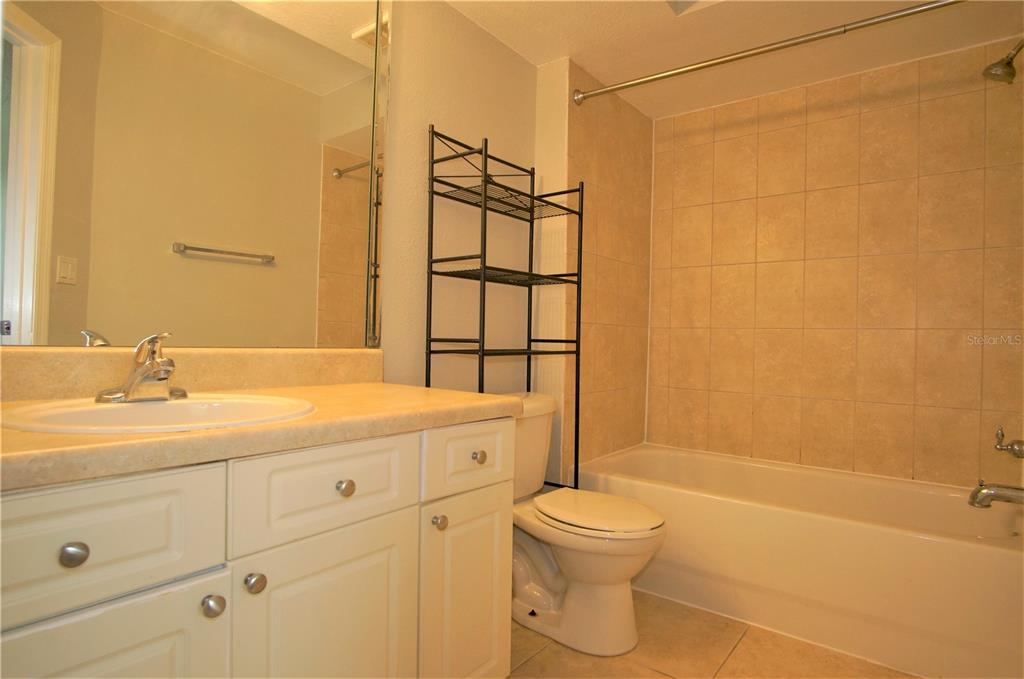 4572 Commander Drive, Unit 1237 Orlando, FL 32822 - Photo 16 of 31 a bathroom with a granite countertop sink toilet and shower