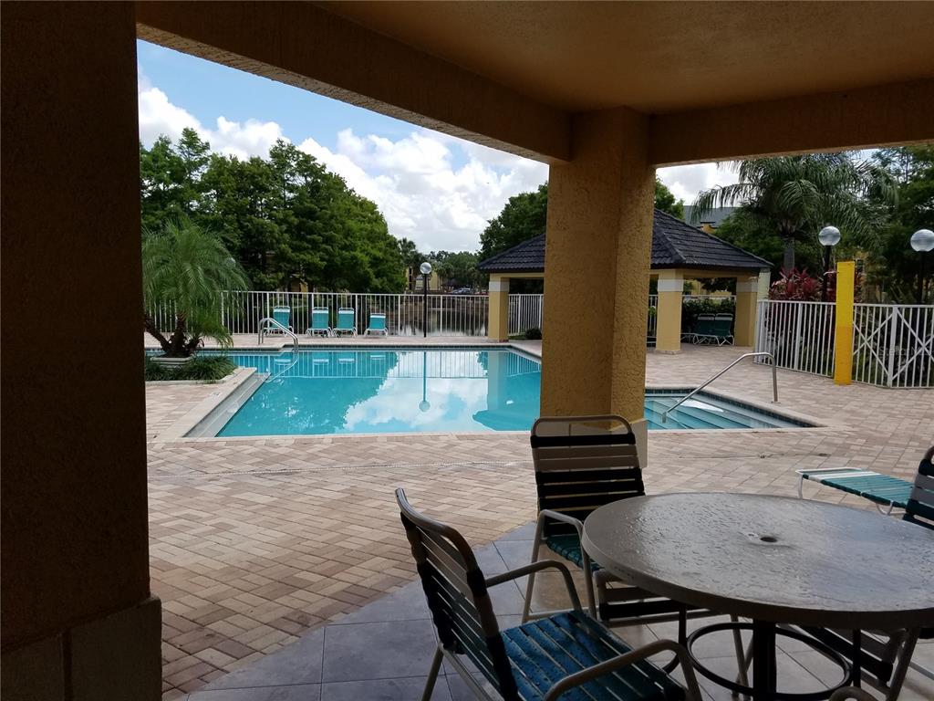 4572 Commander Drive, Unit 1237 Orlando, FL 32822 - Photo 24 of 31 a view of a backyard dining table and chairs with wooden floor