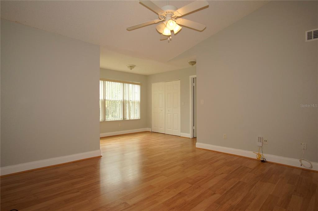 4572 Commander Drive, Unit 1237 Orlando, FL 32822 - Photo 4 of 31 an empty room with wooden floor fan and windows