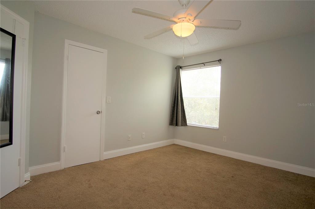 4572 Commander Drive, Unit 1237 Orlando, FL 32822 - Photo 8 of 31 an empty room with a window and a fan