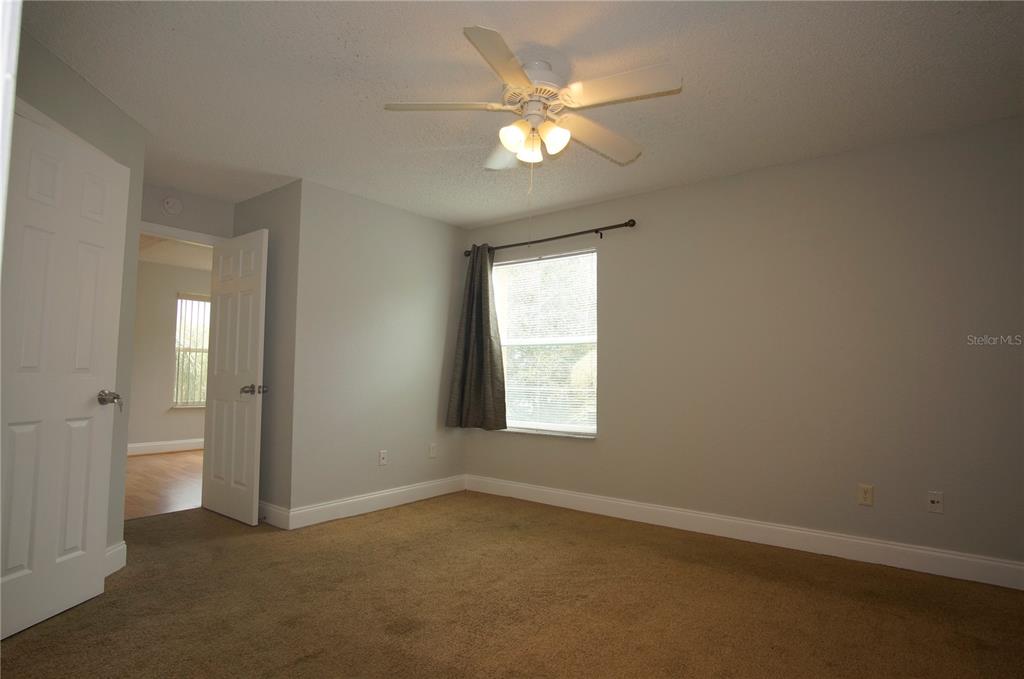 4572 Commander Drive, Unit 1237 Orlando, FL 32822 - Photo 9 of 31 an empty room with a chandelier fan and windows