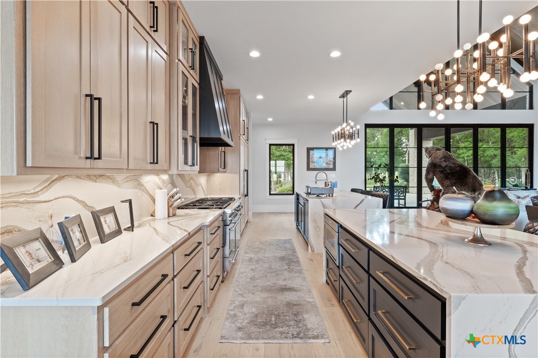 19102 Post Oak Road Bartlett, TX 76511 - Photo 11 of 43 a large white kitchen with a large window and stainless steel appliances