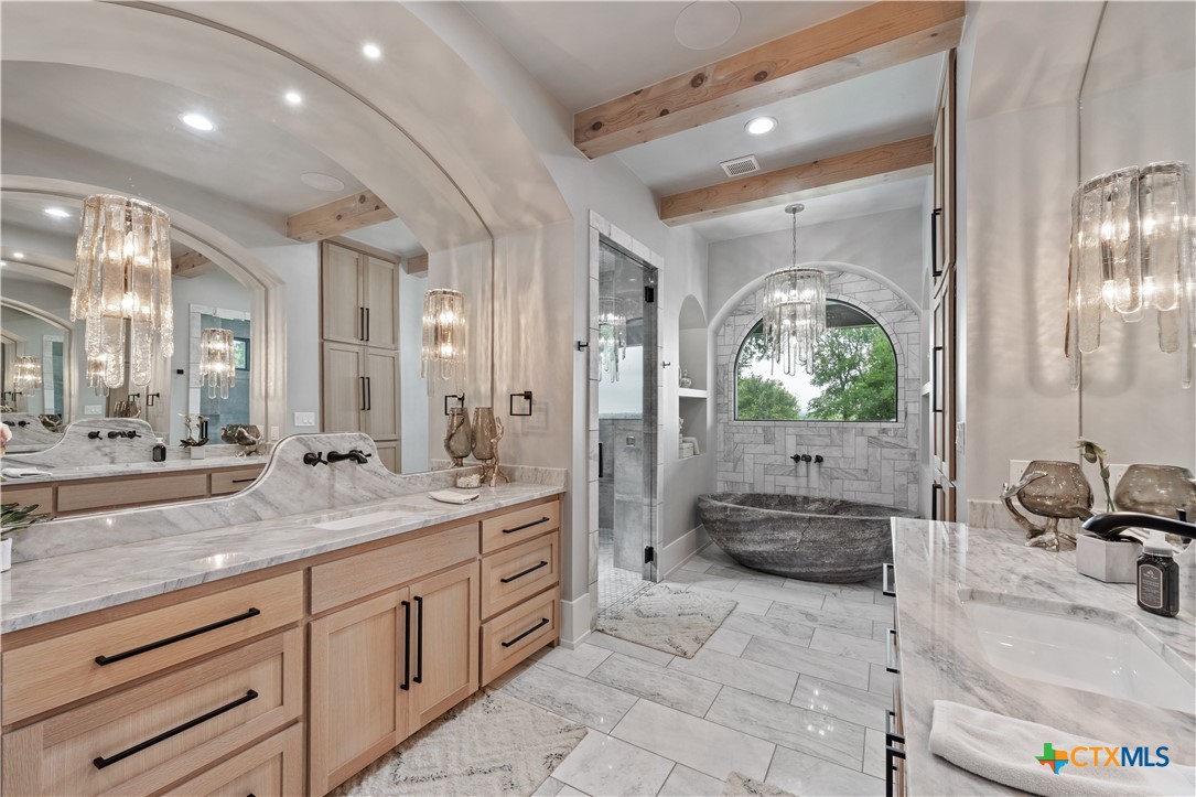 19102 Post Oak Road Bartlett, TX 76511 - Photo 20 of 43 a spacious bathroom with a granite countertop sink a mirror a vanity and a shower