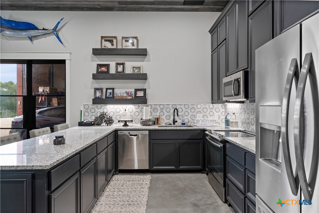 19102 Post Oak Road Bartlett, TX 76511 - Photo 32 of 43 a kitchen with stainless steel appliances granite countertop a sink stove and refrigerator