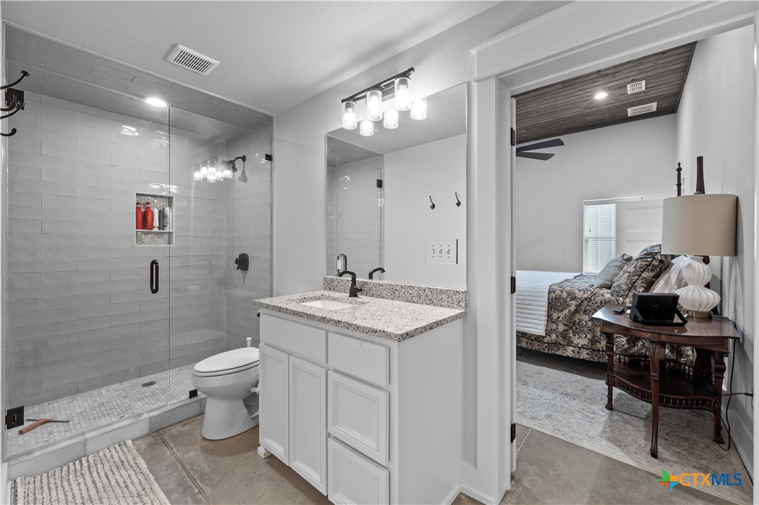 19102 Post Oak Road Bartlett, TX 76511 - Photo 36 of 43 a en suite bathroom with a granite countertop sink a toilet and shower
