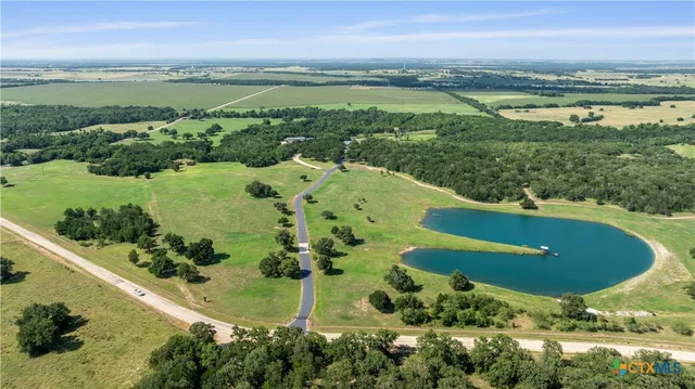 an aerial view of residential houses with outdoor space and trees all around