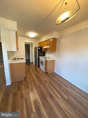 a kitchen with cabinets and wooden floor